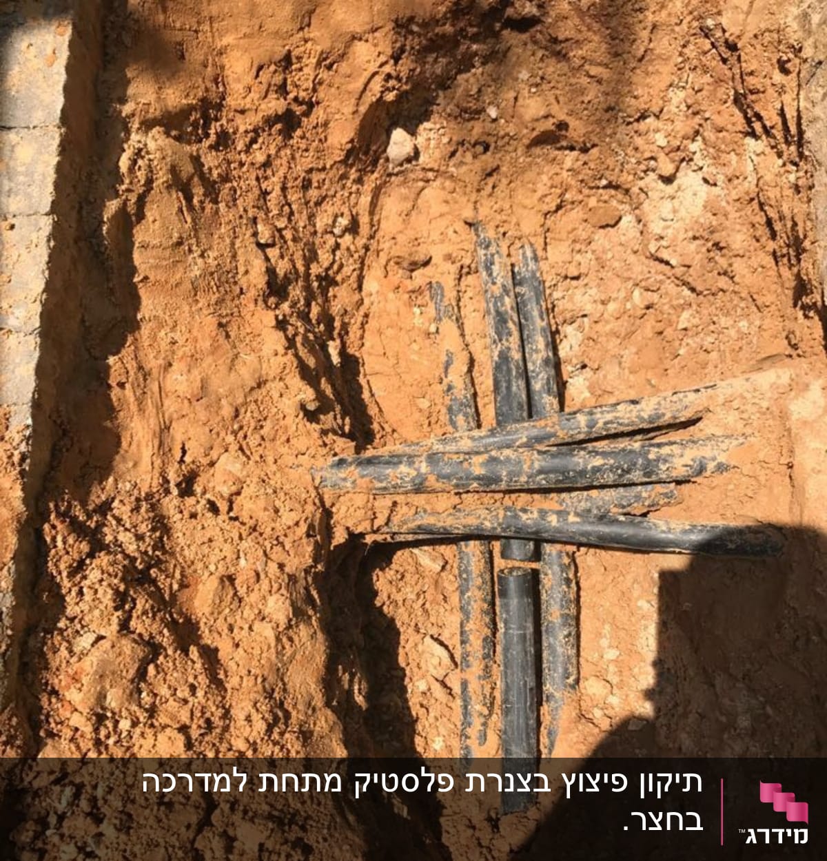 צינורות שחורים מונחים בתוך חפירה באדמה